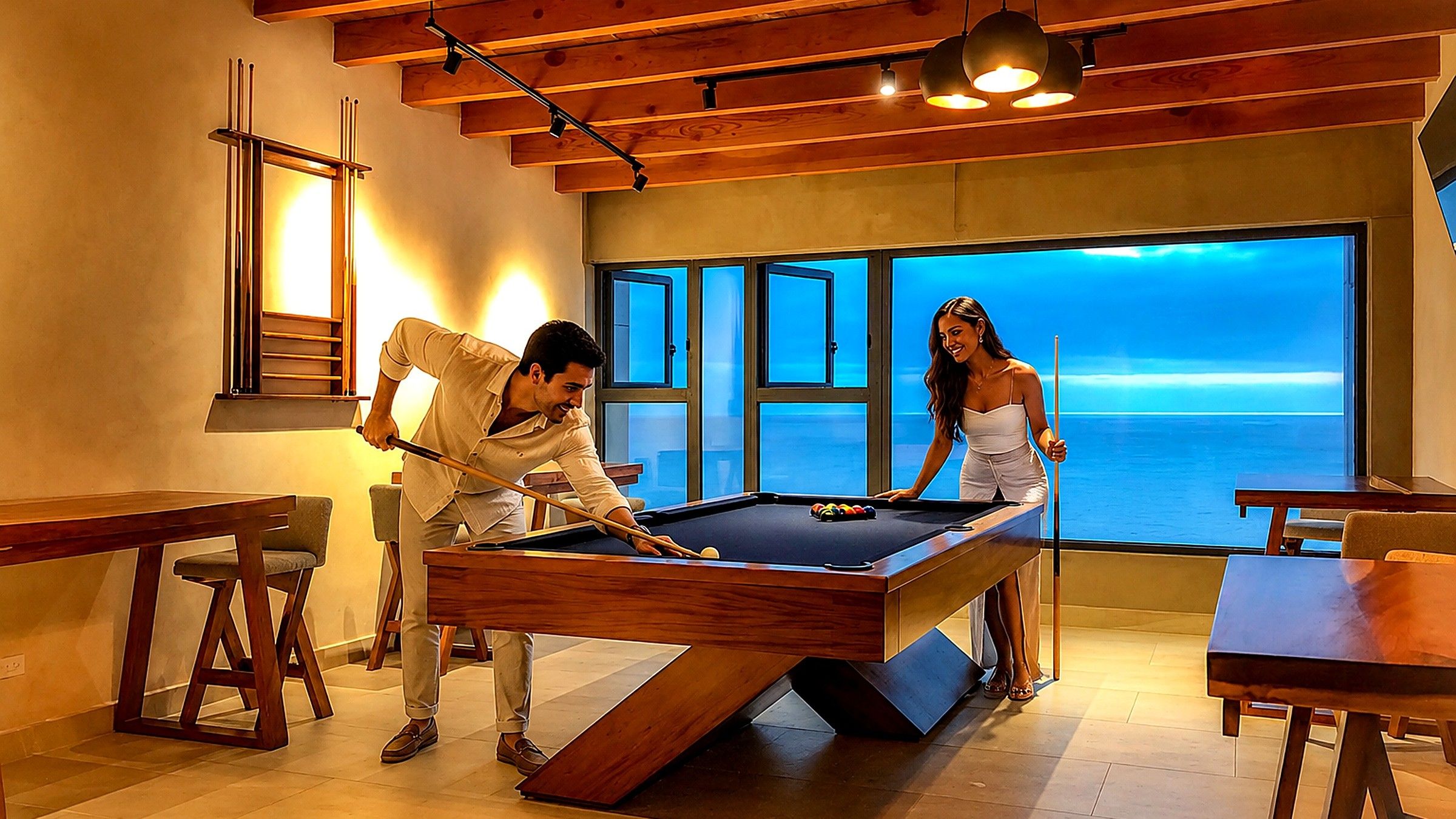 Couple playing billiards with ocean views at dusk